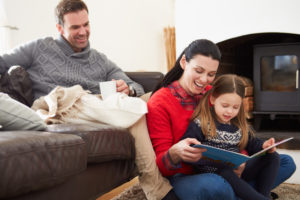Family Relaxing Indoors And Reading Book
