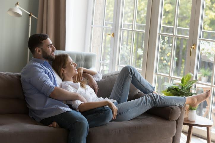 Couple sitting indoors enjoying air conditioning and heating services in Arlington