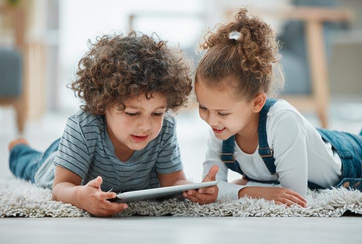 Comfortable indoor warmth thanks to reliable heating service Kids sitting comfortably indoors, watching a tablet in a warm, cozy room.