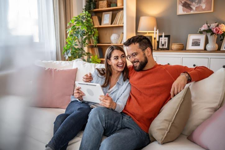 Couple reviewing new AC and heating system options on a tablet at home in Irving.