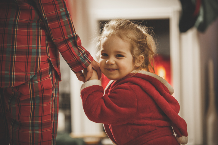 Cute girl in a bathrobe holding hands with her mother in a cozy home setting