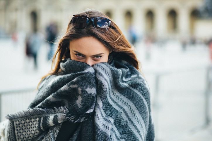 Girl wrapped in a shawl feeling cold while furnace is running